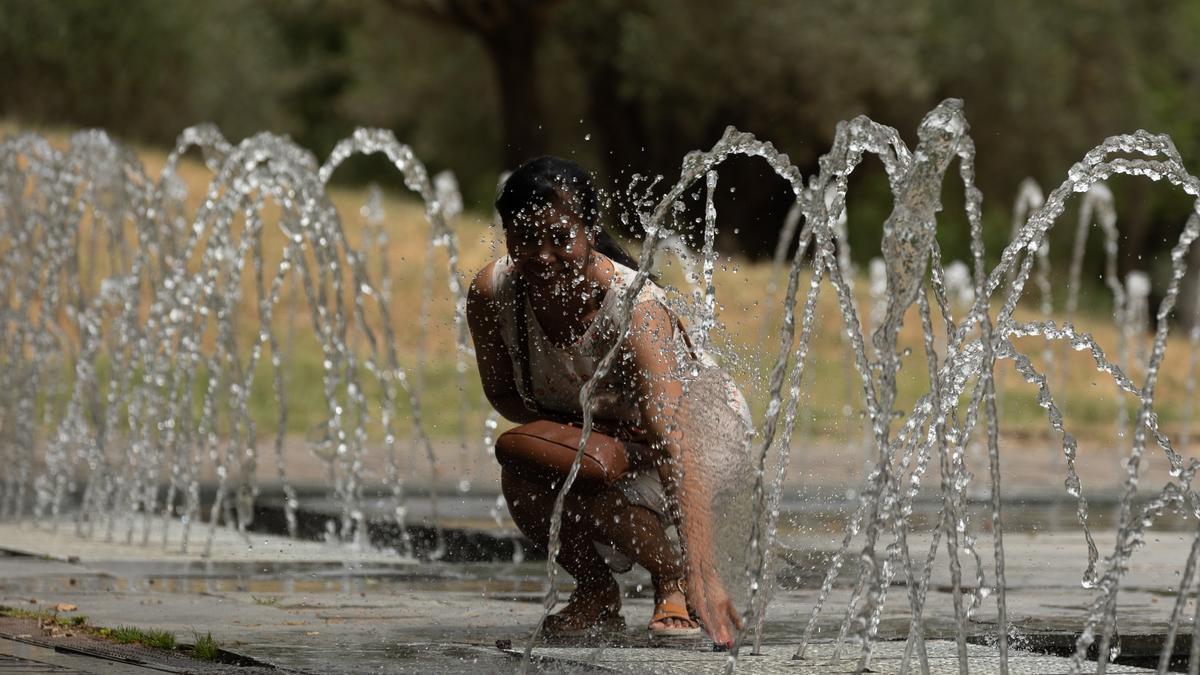 Una mujer se moja en los chorros de Madrid Río para aliviar la ola de calor.