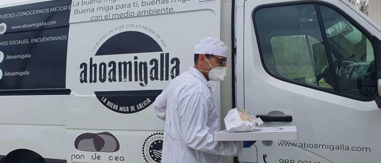 Un trabajador distribuye pan de cea y empanada con todas las medidas de prevención. // Fdv