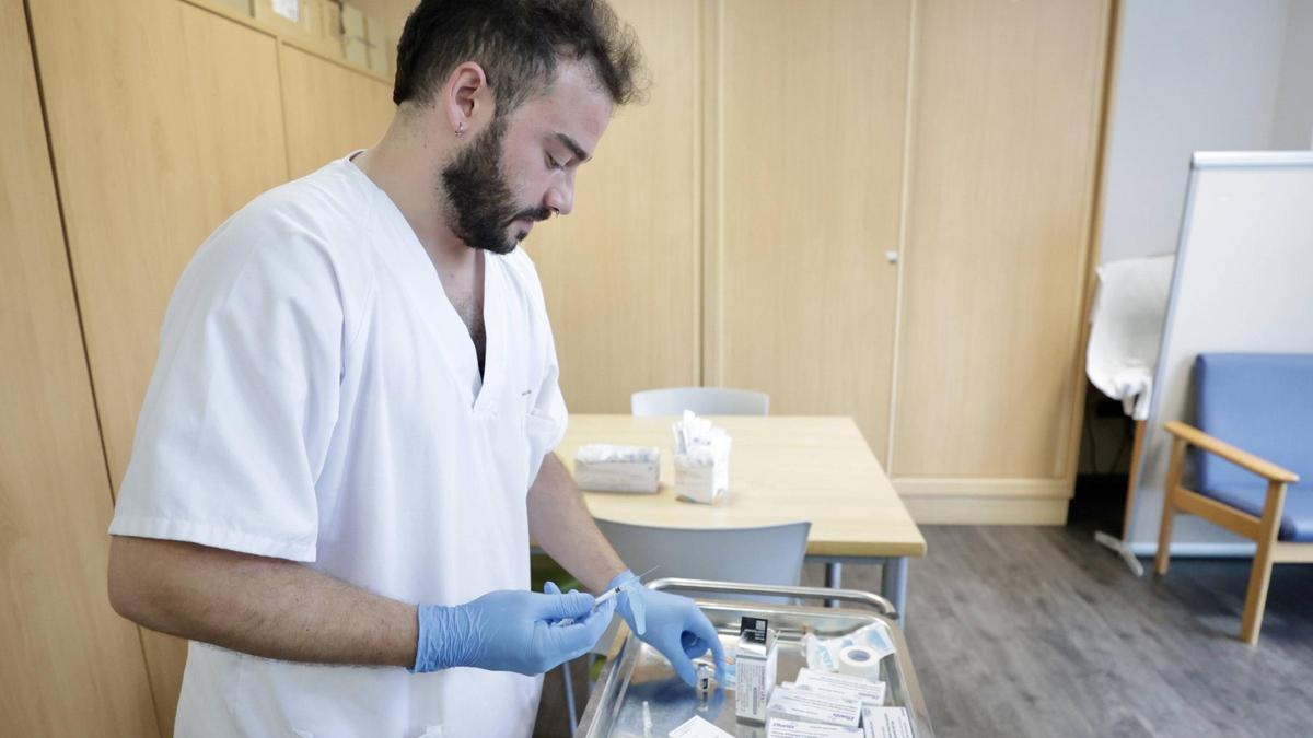 Un enfermero de Oviedo prepara una dosis de vacuna de la gripe para aplicarla a un paciente.