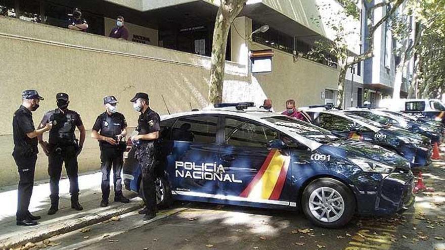 Die Polizisten streiten sich darum, wer zuerst mit dem neuen Auto fahren darf.