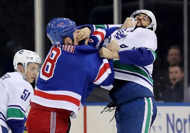 Cody McLeod # 8 de los New York Rangers y Darren Archibald # 49 de los Vancouver Canucks pelean en el segundo período en el Madison Square Garden.