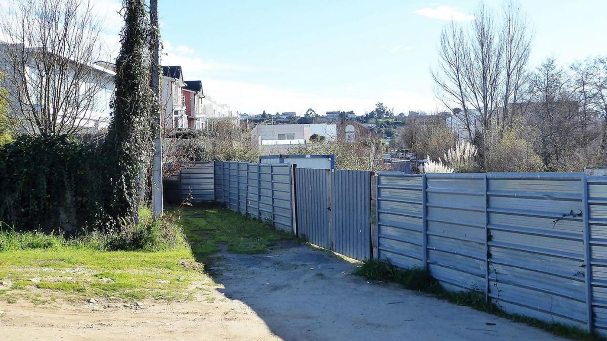 Valla al final del camino de O Riveiro y, detrás, la calle Juno, en la urbanización Icaria. |   // L.O.