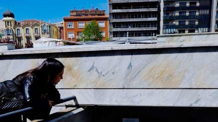 Una joven observa las filtraciones de la fuente.