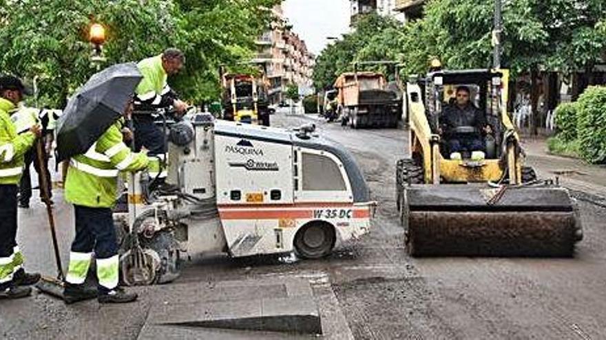 Operaris treballant a la part sud del carril de baixada del passeig de la Pau, ahir