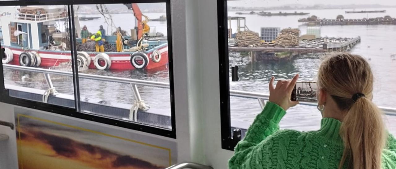 Una turista fotografía a los bateeiros desde el barco de pasaje &quot;Fly Delfín&quot;.