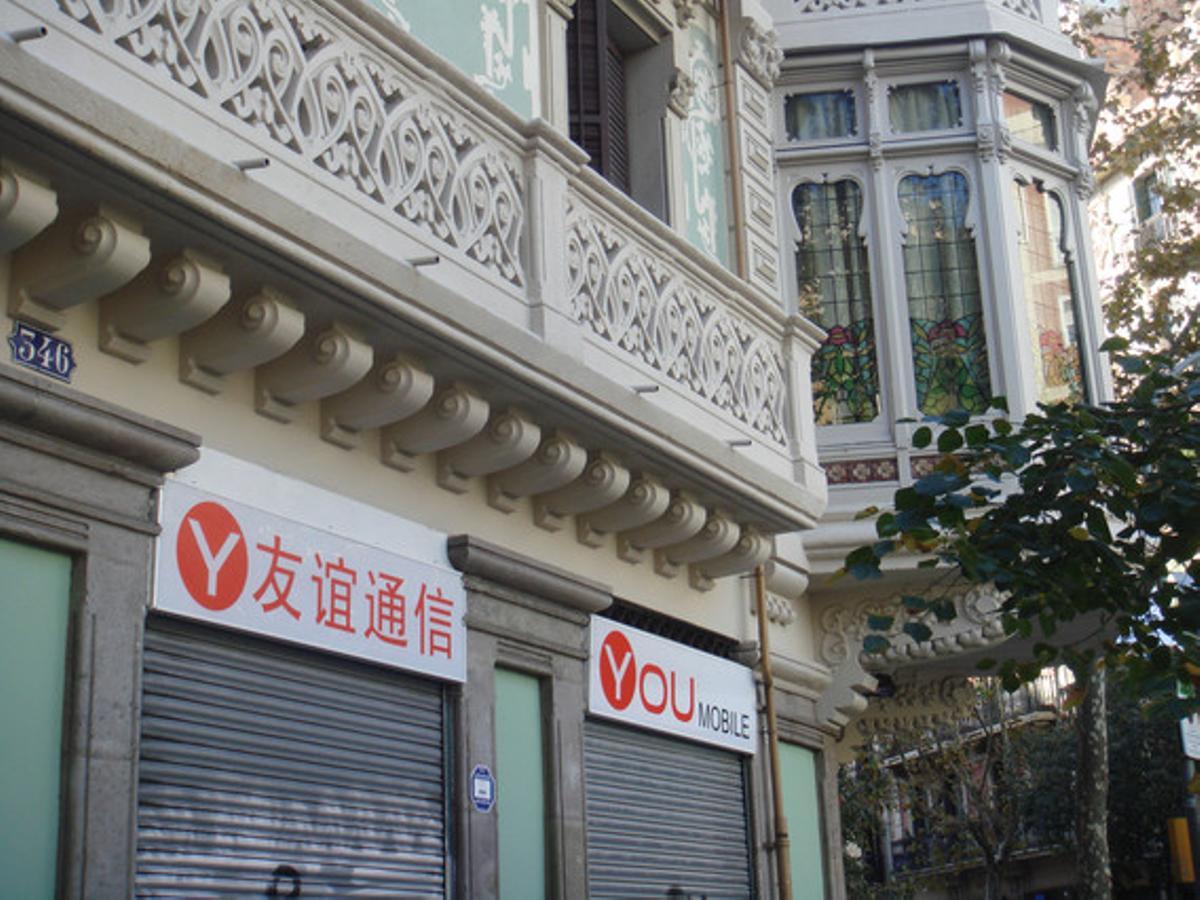 Ni en català ni en castellà. Veiem sovint cartes de protesta per multes que han imposat la Generalitat o l’Ajuntament de Barcelona per rètols de comerços en castellà. Els cartells de l’establiment de la foto (situat a la cantonada dels carrers de la Diputació i Roger de Flor) estan en xinès i en anglès. És a dir, ni en català ni en castellà, cosa que constitueix una infracció doble, a més d’una agressió al paisatge urbà, ja que es tracta d’un edifici modernista.