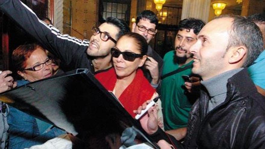 Momento en el que Isabel Pantoja atiende a un grupo de fans a su llegada ayer por la noche al hotel Santa Catalina.