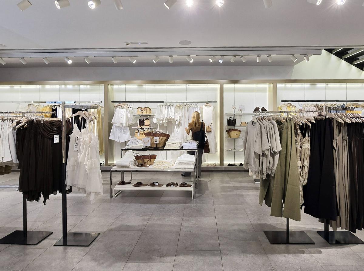 Prendas de colores neutros y sin estampados en diversas tiendas de ropa en Vigo.
