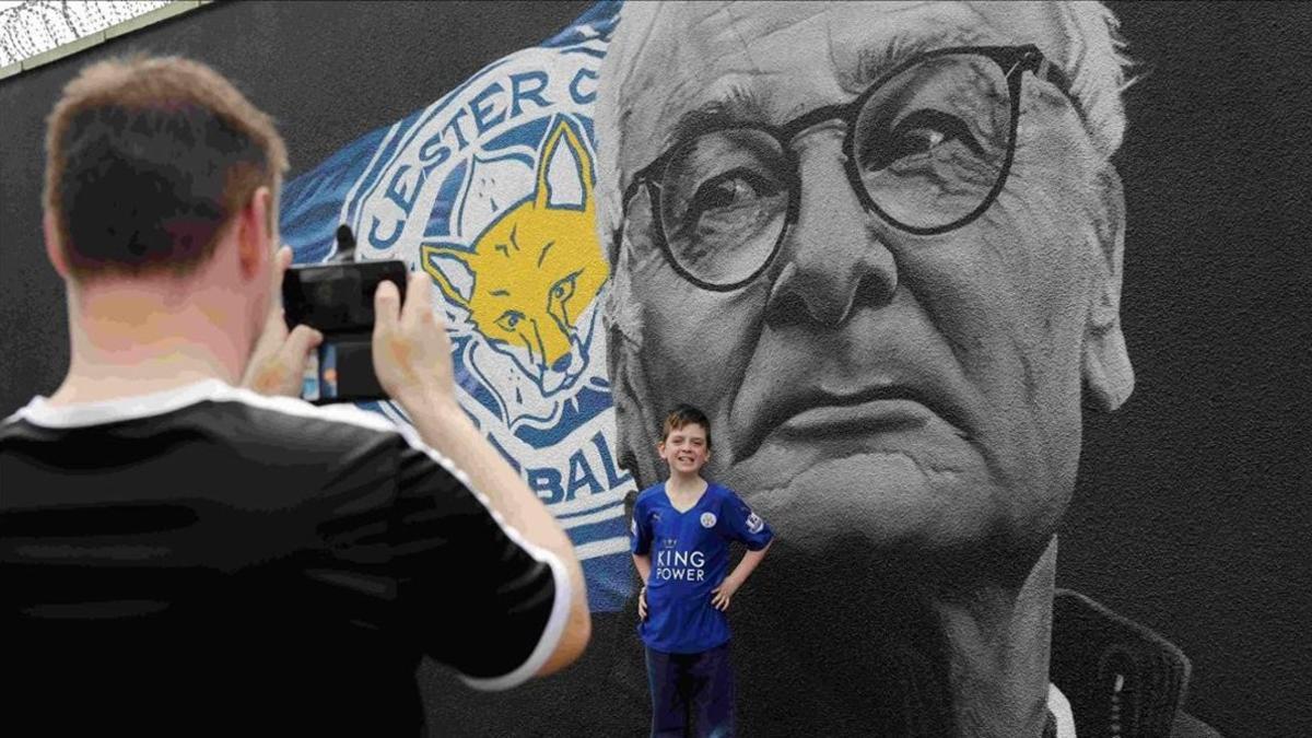 Un chico posa ante un mural de Claudio Ranieri en Leicester.