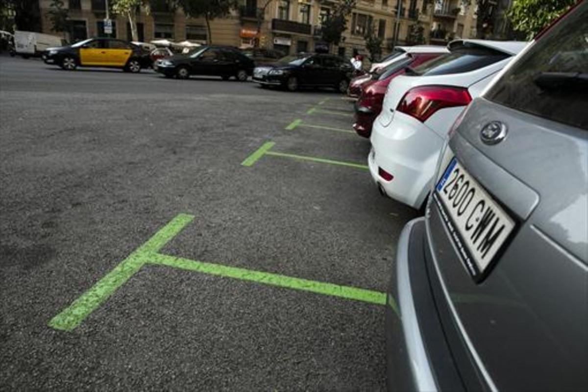 Coches estacionados en plazas de zona verde en el Eixample.