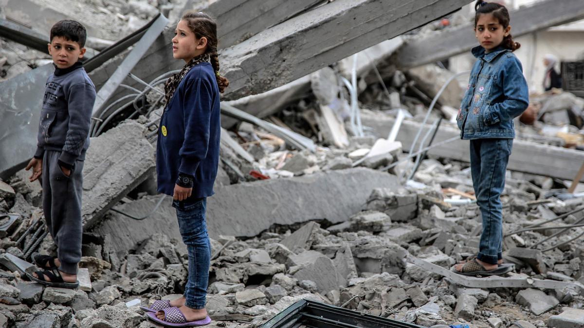 Niños palestinos miran los escombros en la ciudad de Gaza