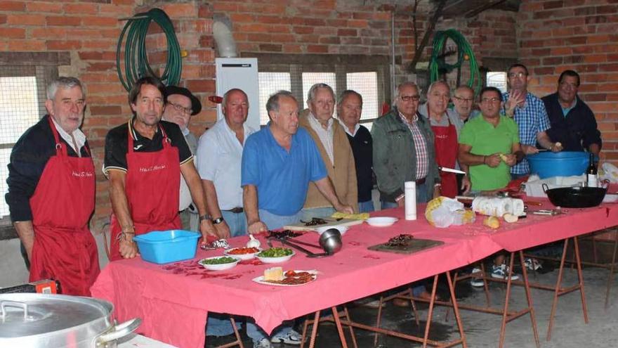 Voluntarios de la Hermandad de San Antón preparando la comida de ayer en el llagar de Mestres.
