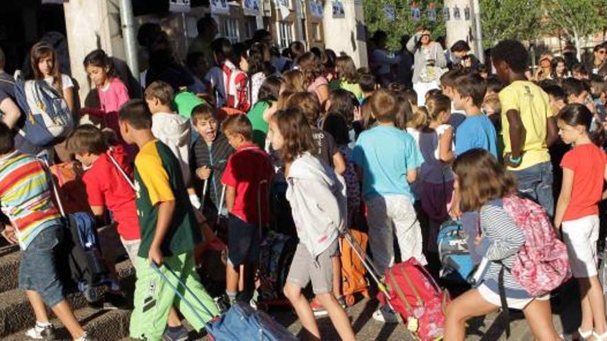 Alumnos hacen cola para entrar a su colegio el primer día de curso después de las vacaciones de verano.