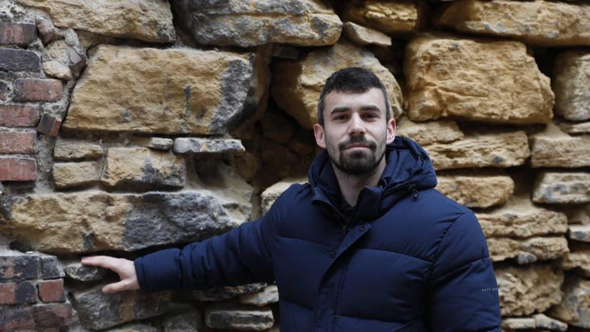 Nacho Abella, ayer, en la calle del Peso. Abajo, con el parche de la Champions en la camiseta del Oviedo, durante el Mundial. | FERNANDO RODRÍGUEZ