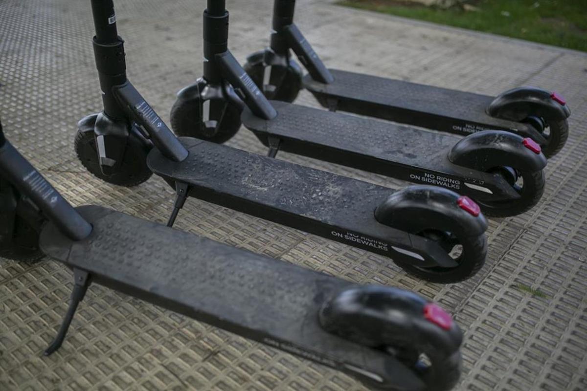 Patinetes eléctricos de alquiler aparcados en la acera.