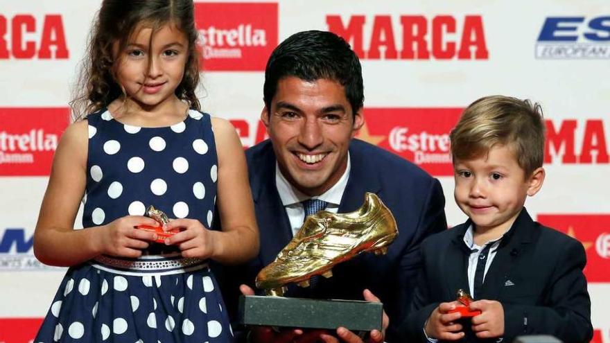 Suárez posa con la bota de oro junto a sus dos hijos. // Efe