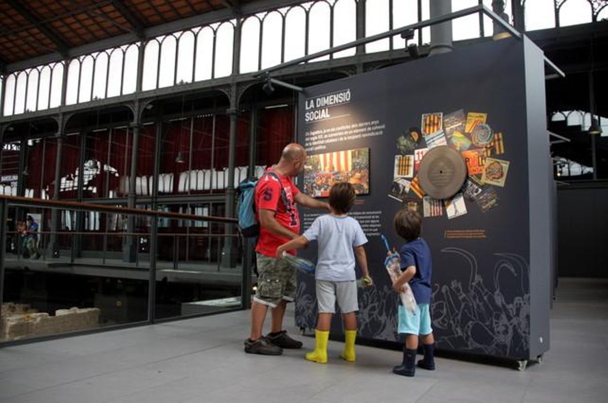 Un pare ensenya als seus fills un dels plafons de la mostra ’Bon cop de falç. La història de l’himne’ aquest dimecres al Born Centre Cultural.