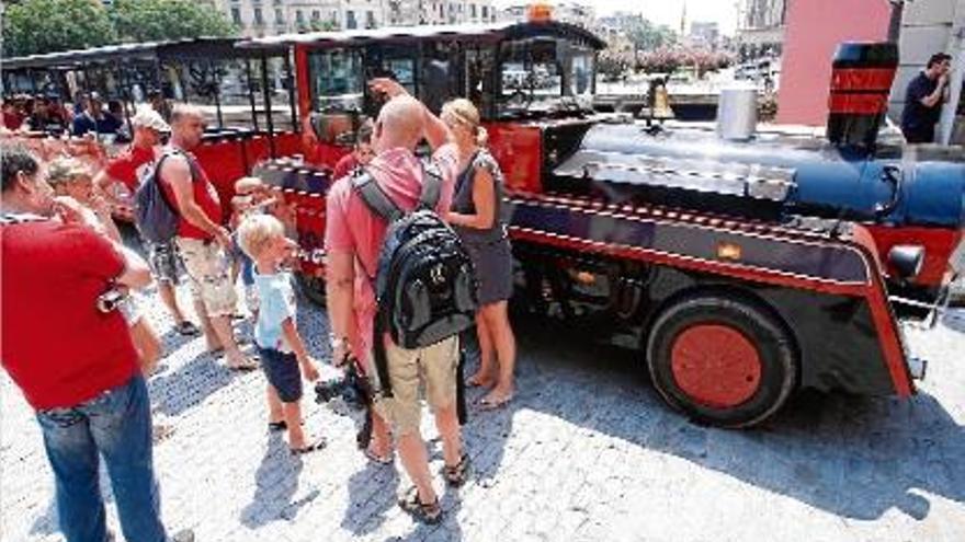 Turistes a punt d&#039;agafar el trenet turístic de la ciutat de Girona.