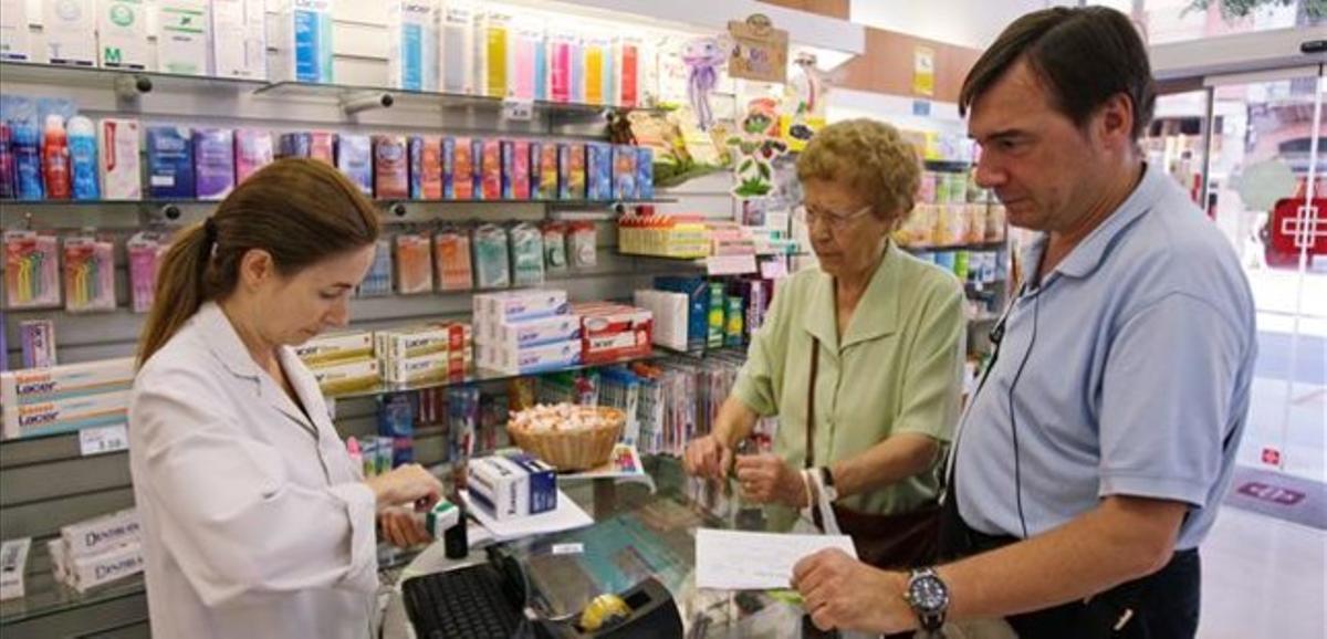 Una dependenta atén uns clients en una farmàcia de Barcelona. Una dependenta atén uns clients en una farmàcia de Barcelona.