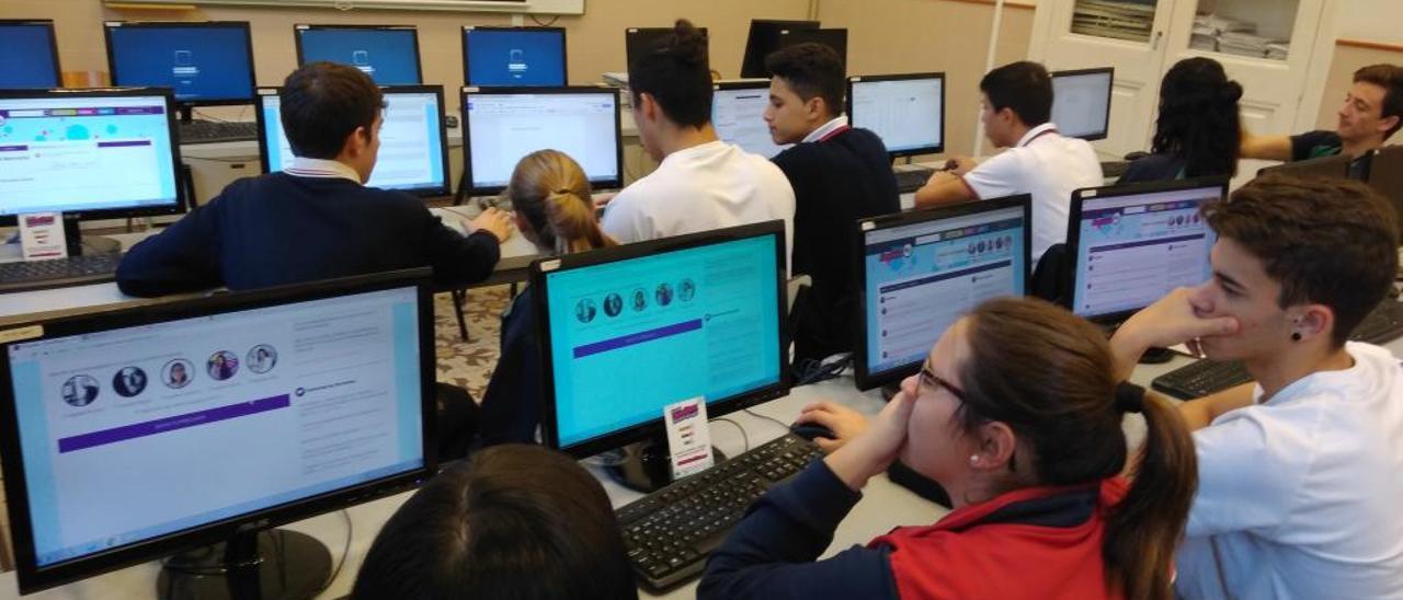 Alumnos de un colegio de Gandia en una sala llena de ordenadores personales.