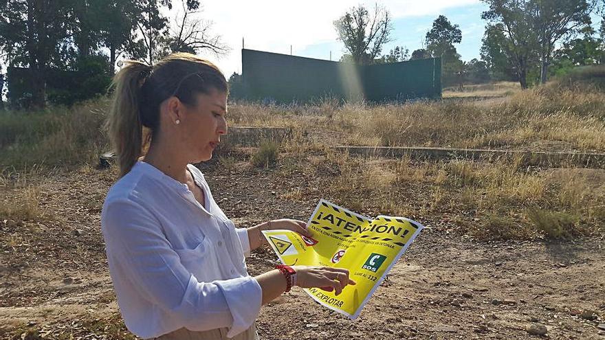 La edil Rosa María Medina, con un cartel de advertencia.