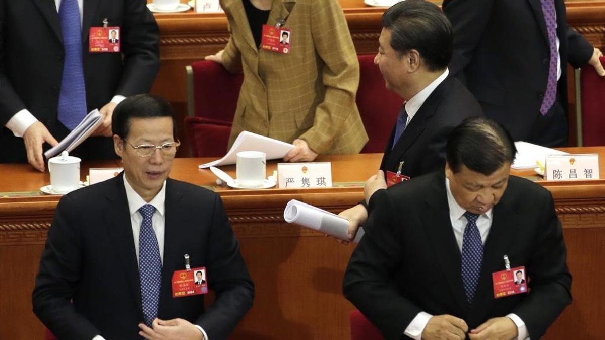 Xi pasa junto a los miembros del Politburó Liu Yunshan (derecha) y Zhang Gaoli (izquierda), en la sesión plenaria de la Asamblea Nacional Popular de China, en Pekín, el 13 de marzo del 2016.