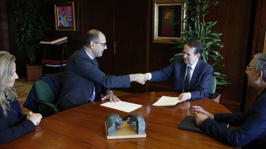 Frèdèric Puech (izq.) y Abel Caballero estrechan la mano durante la firma del convenio entre PSA y el Concello. // R. Grobas