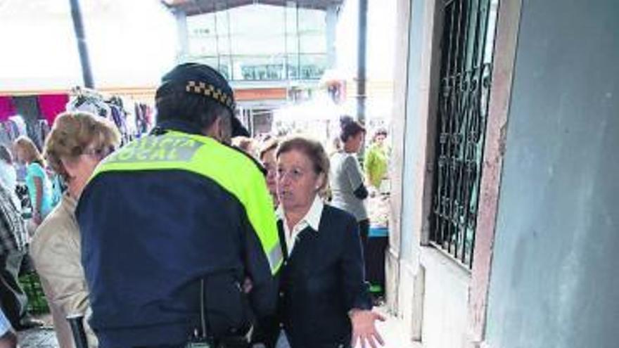 Un agente dialoga con las vendedoras en una de las entradas de la plaza.