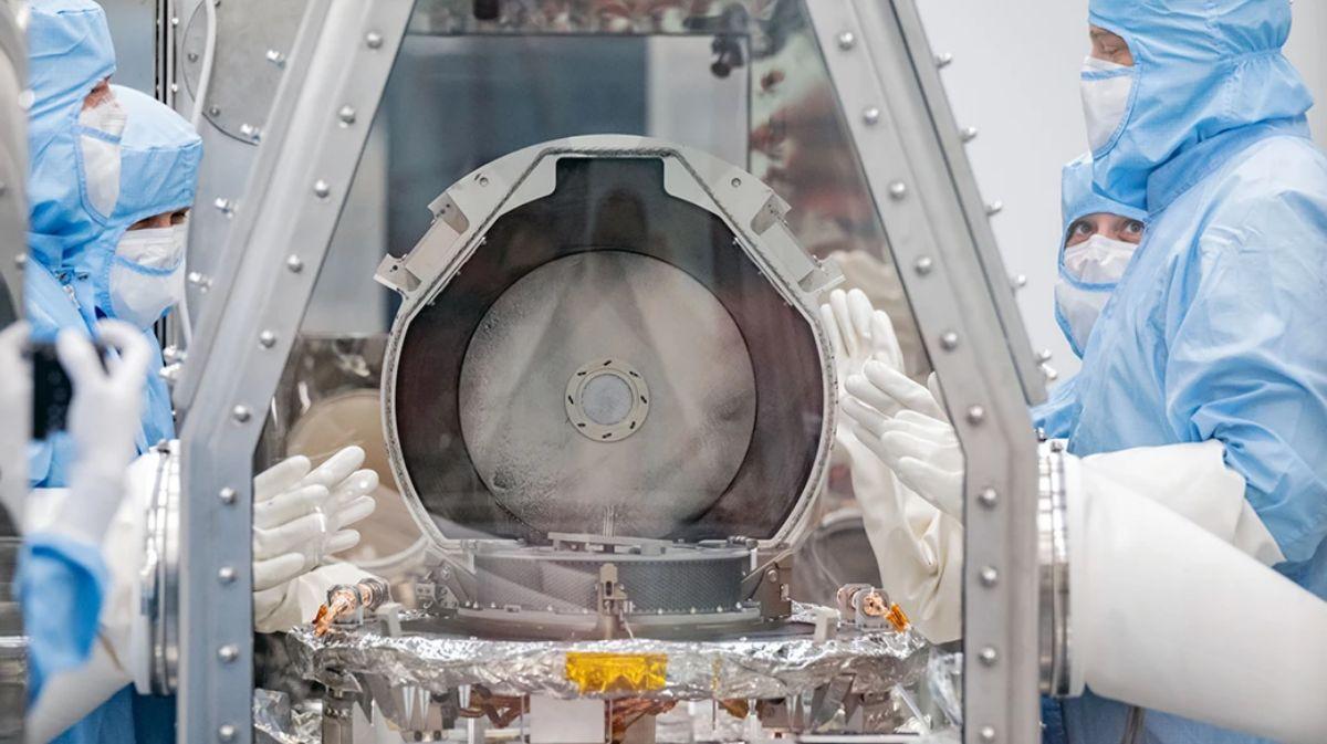 Los investigadores abren un recipiente que contiene fragmentos del asteroide Bennu, en un laboratorio preparado con gas inerte para evitar la contaminación.
