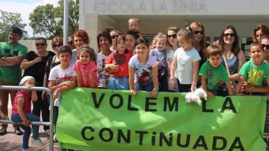 Un grup de pares i alumnes protestant ahir davant l&#039;escola La Sínia de per reclamar la jornada continuada.