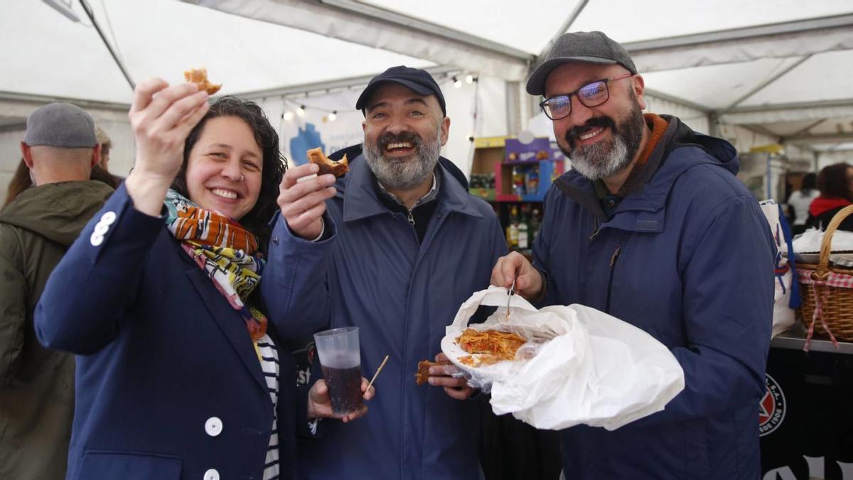 Por la izquierda, Lucía Mateo, Jaime García y Bruno Pérez, ayer, comiendo una empanada bajo la carpa del Oviedo Antiguo.