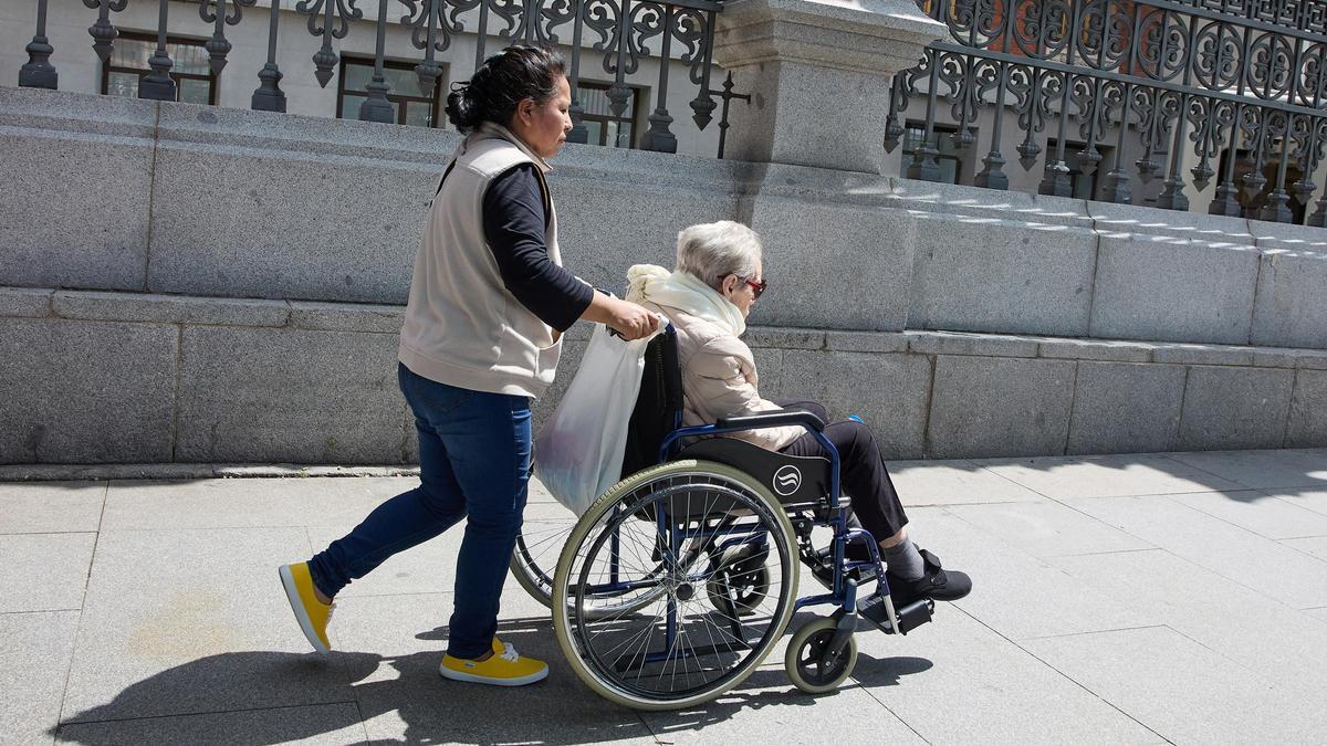 Una mujer mayor dependiente y su cuidadora pasean por la ciudad.
