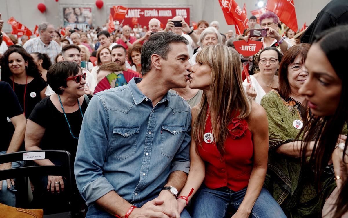Pedro Sánchez besa a su mujer, Begoña Gomez, con una chapa de 'Perra Sanxe', en el mitin de cierre de campaña.
