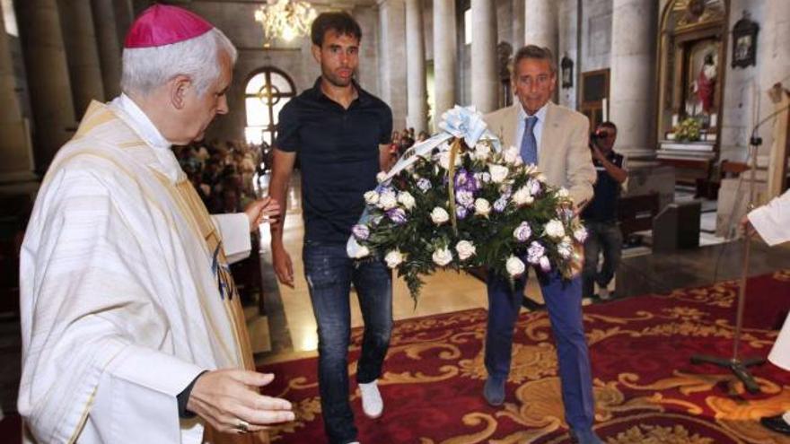 Borja Oubiña y Carlos Mouriño realizan la ofrenda al Cristo de la Victoria ante la mirada del obispo Luis Quintero. // Ricardo Grobas