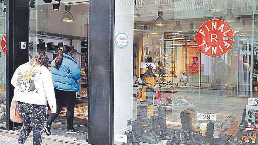 Viandantes entrando en una tienda en Vigo.  | // ALBA VILLAR