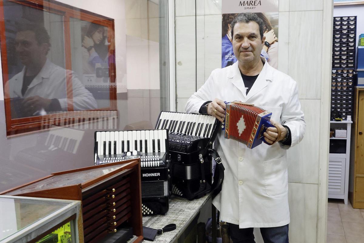 El relojero Manolo Olegario, con acordeones que también repara en su taller de la calle Pizarro