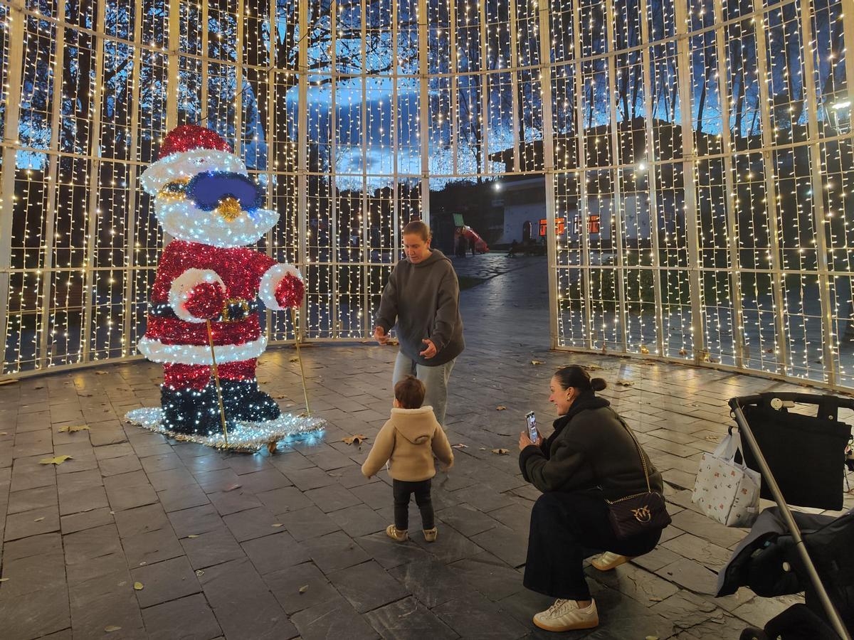 Unos vecinos, fotografiándose con el Papá Noel esquiador.