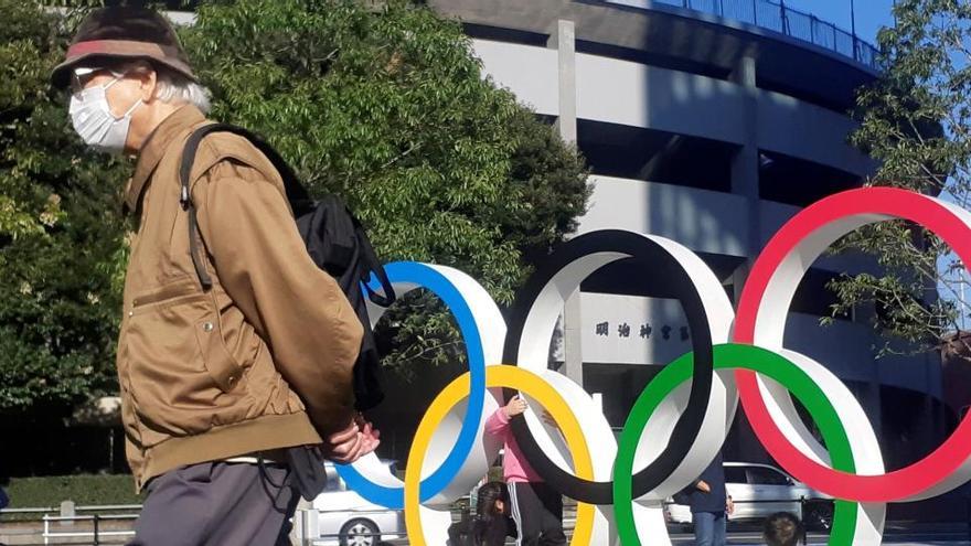 Un hombre pasea junto a los anillos olímpicos instalados en Tokio.