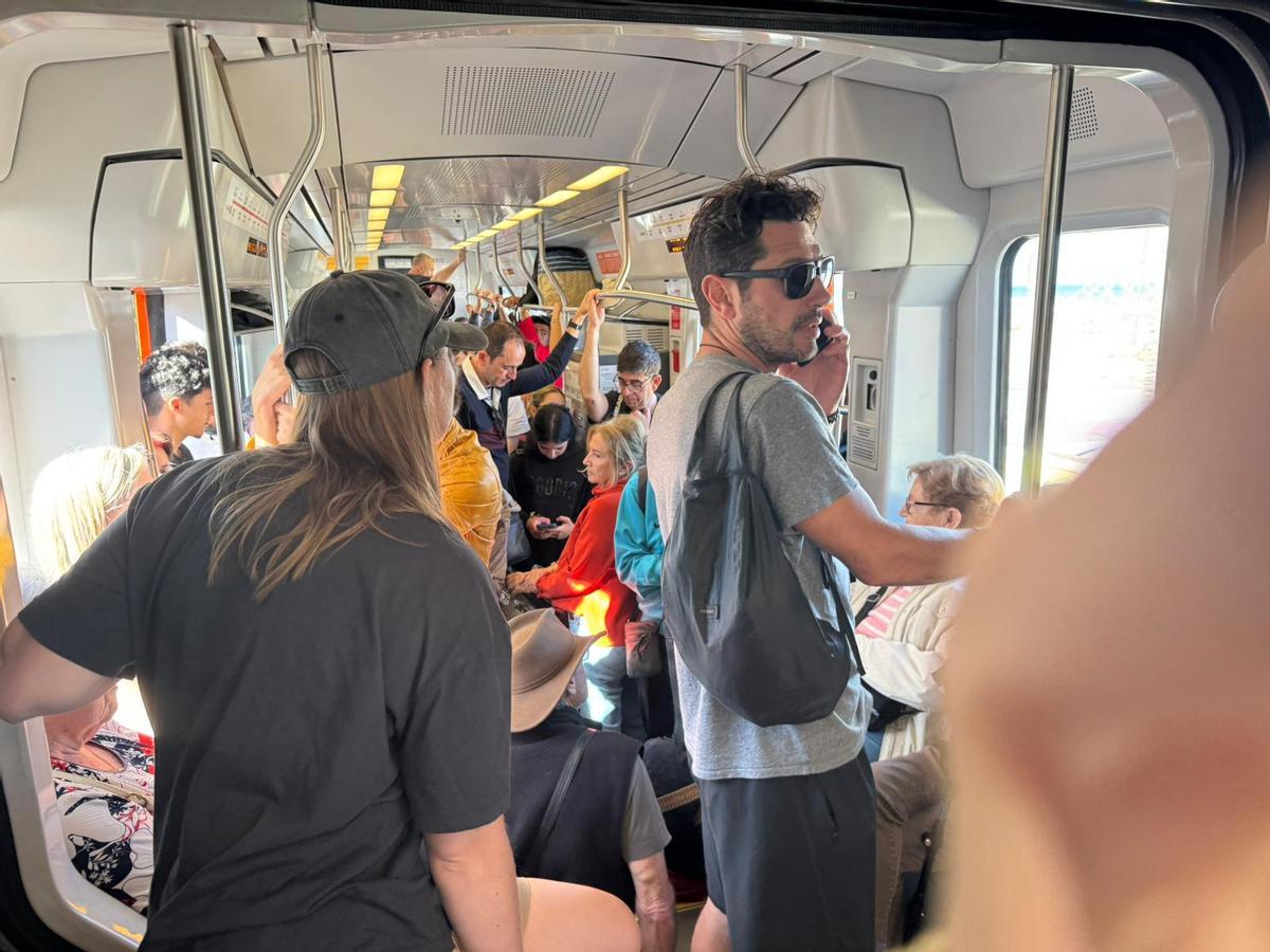 Usuarios como sardinas en el tram a su paso por la playa de Muchavista.