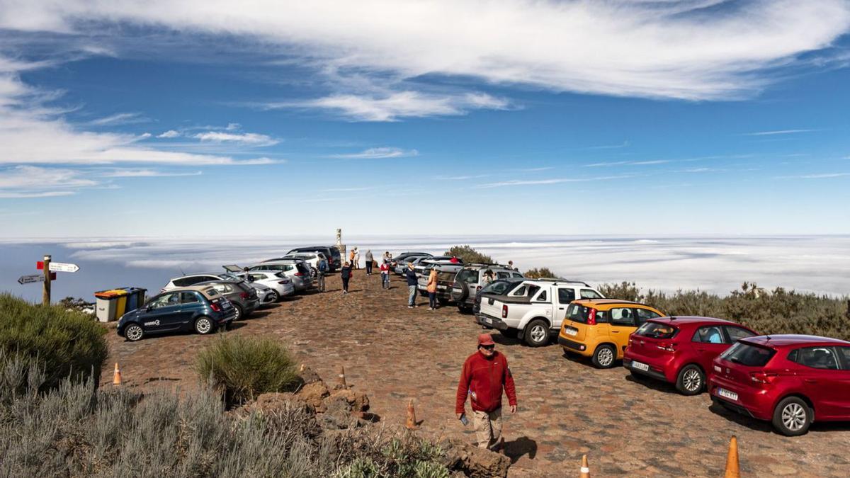 Una pareja de turistas pasea por el Roque de los Muchachos bajo la mirada de los cuervos