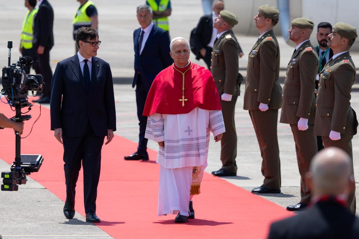 El papa León XIV, a su llegada al aeropuerto de Barcelona. A su lado, el presidente de la Generalitat, Salvador Illa.