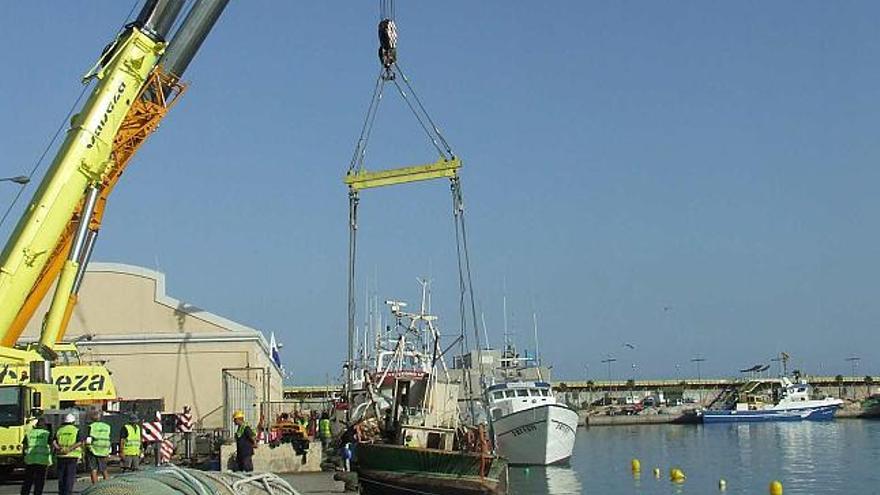 Un momento de las labores de extracción del pesquero hundido en las aguas del puerto, en una imagen de ayer.
