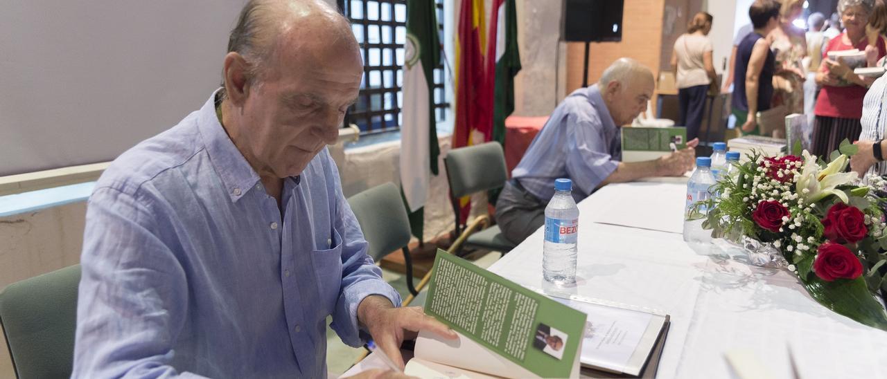 Francisco Gaona Lería, en primer plano, y Francisco Sánchez Gil, al fondo, firman ejemplares del libro.