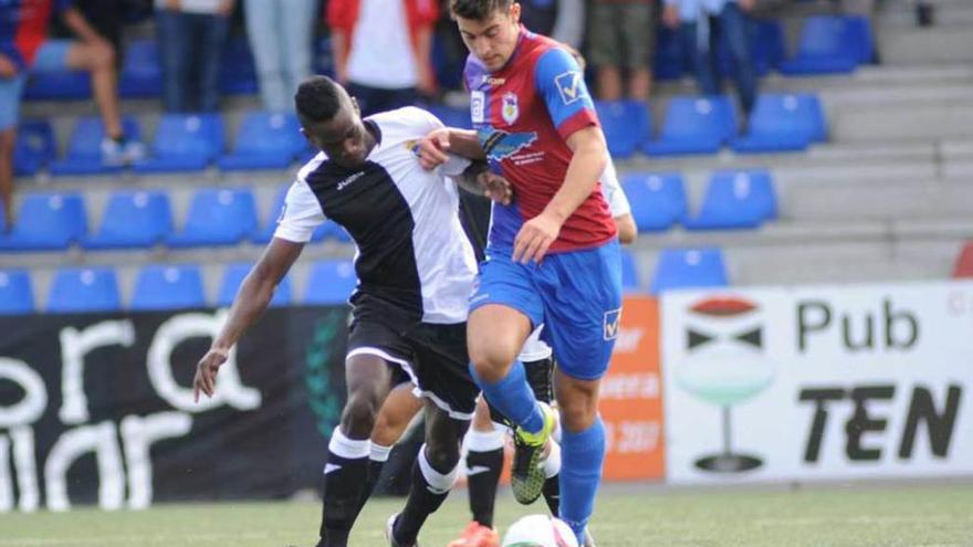 El jugador del Urraca Rony, a la izquierda, presiona a Claudio, del Langreo, en el Nuevo Ganzábal.