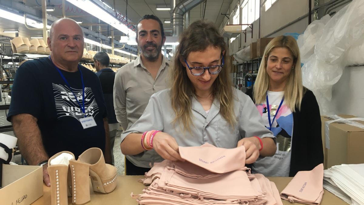 El presidente de Asprodis, el gerente de Manufacturas Flyer y la directora del Servicio de Empleo de Asprodis observando el trabajo de Mónica Márquez.