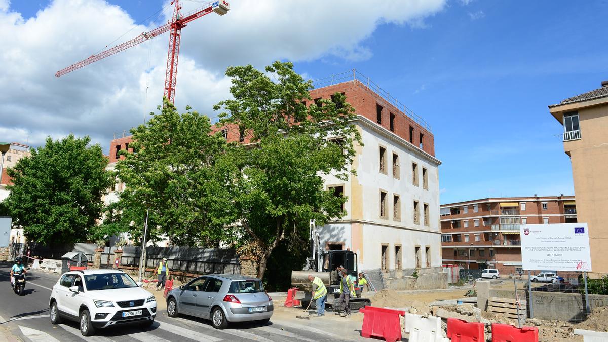 Vista de las obras en la calle, con los pabellones, al lado.