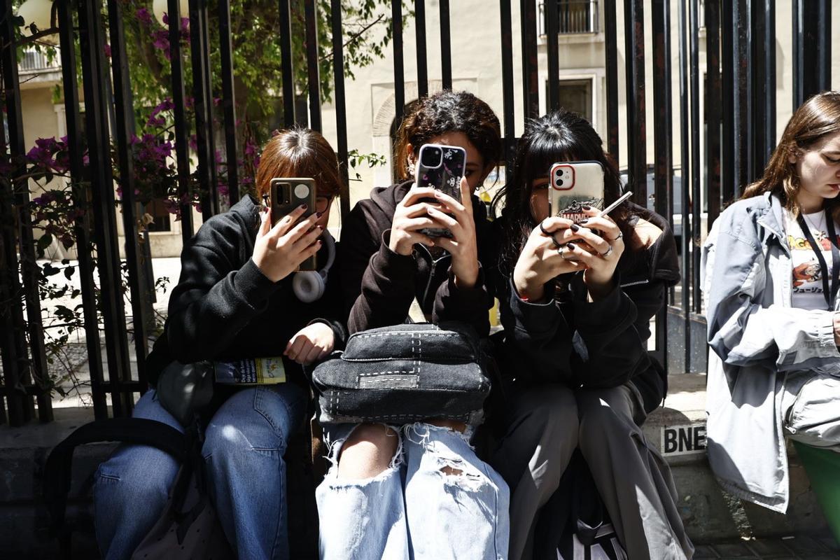 Varias estudiantes del IES Lluis Vives de València con sus teléfonos móviles.