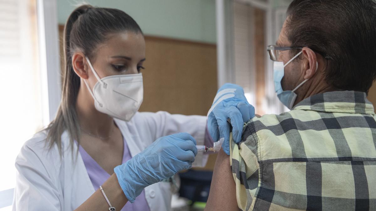 Imagen de archivo de una enfermera vacunando a un hombre contra la gripe y la covid-19.