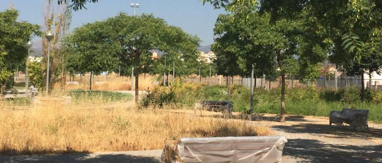 Los bancos siguen plastificados y las malas hierbas crecen en el parque ya construido.