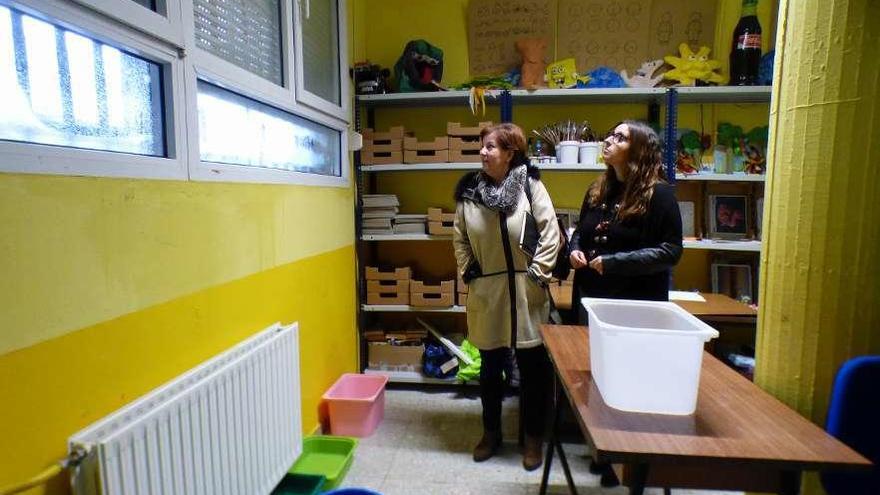 Ana Isabel López y Ana González comprueban el estado de una de las aulas, con cubos para recoger el agua.